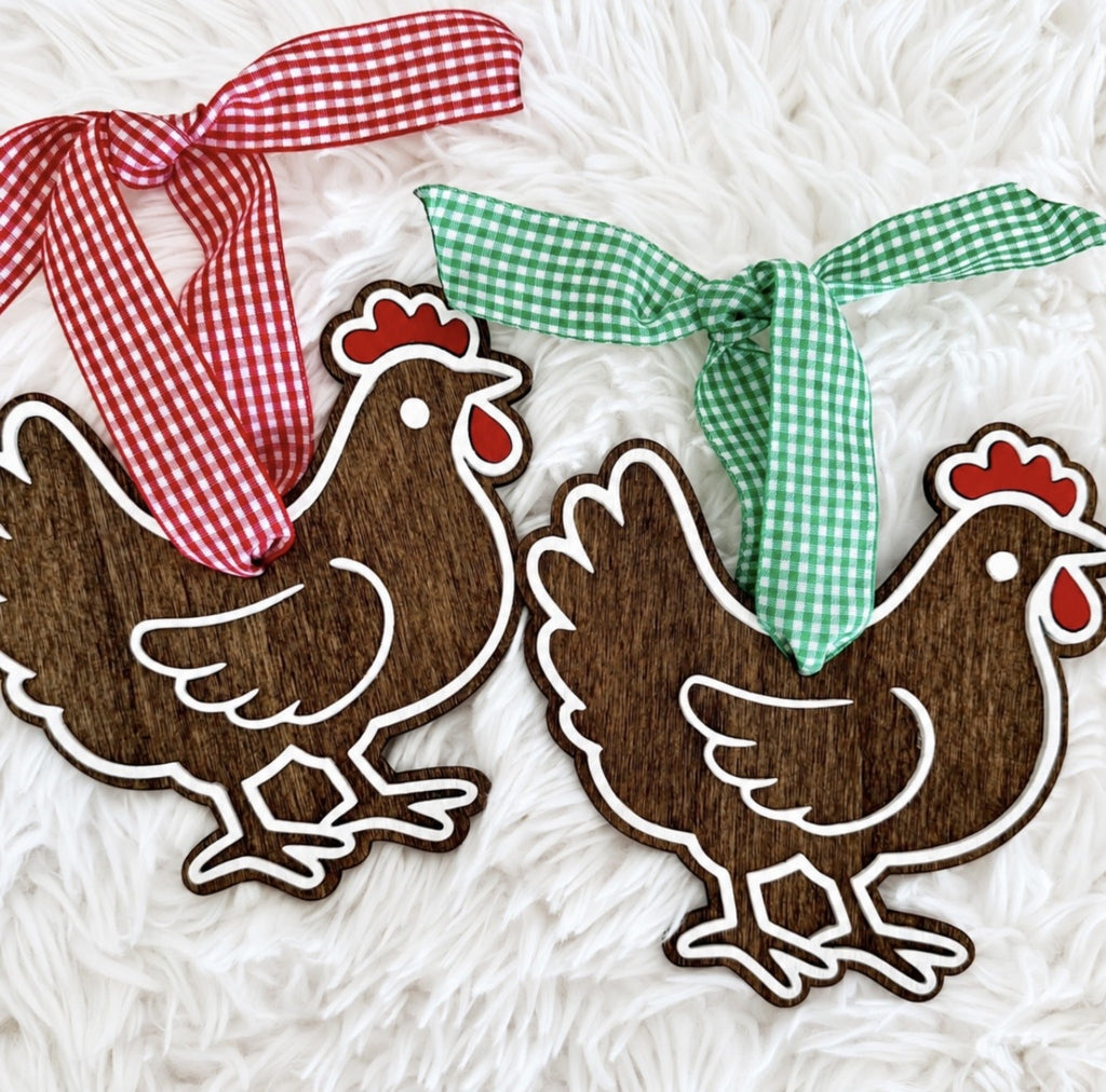 Handmade wooden chicken Christmas ornaments with red and green gingham ribbons and layered white and red details.