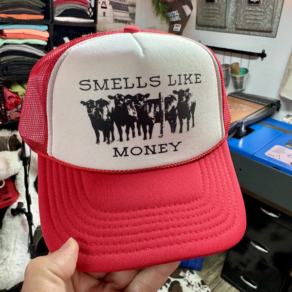 Smells Like Money foam trucker hat featuring cattle graphic on a red and white western-style trucker cap.