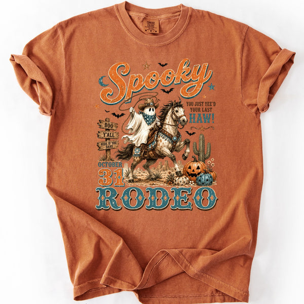 Spooky Rodeo Halloween western graphic tee on a Comfort Colors Yam shirt featuring a ghost cowboy riding a horse with pumpkins, cactus, and vintage retro country artwork