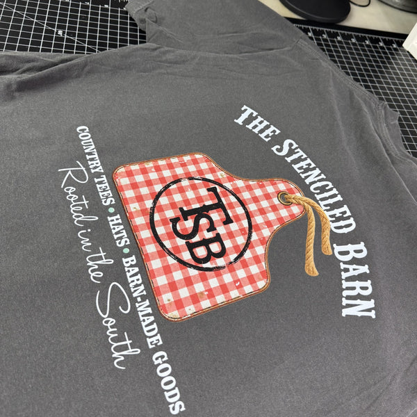 The Stenciled Barn signature Comfort Colors tee with rustic gingham cattle ear tag graphic and white back print