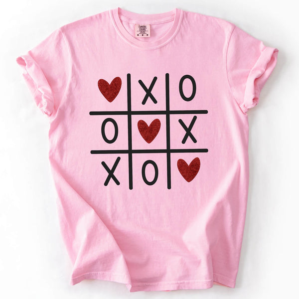 Pink t-shirt with a tic-tac-toe design featuring hearts on a white background
