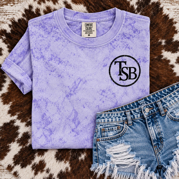 Comfort Colors Amethyst Color Blast tee with black TSB cattle brand left chest design and distressed denim shorts