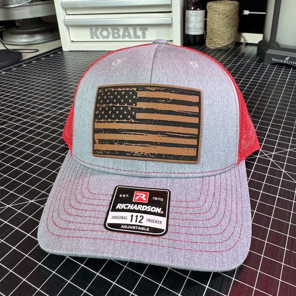 Gray and red Richardson 112 trucker hat with distressed American flag brown leather patch and red mesh back.