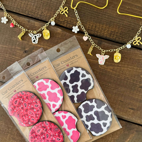 Western car charm necklaces with cowboy charms and car coasters in red paisley, pink cow, and black cow prints.