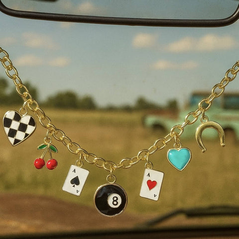 Western charm chain with retro charms hanging from rear view mirror in rustic country setting