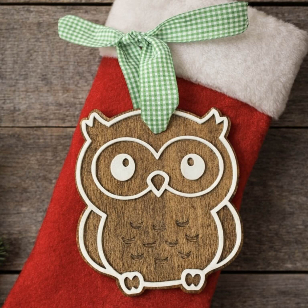 Red Christmas stocking with a wooden owl ornament and green ribbon on a wooden background