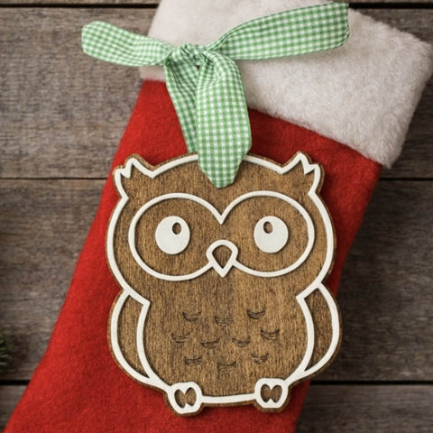Red Christmas stocking with a wooden owl ornament and green ribbon on a wooden background